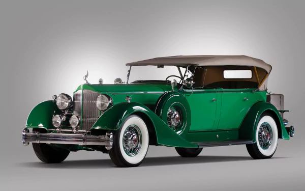 HD desktop wallpaper featuring a vintage green Packard Twelve convertible with classic whitewall tires and a tan soft top.