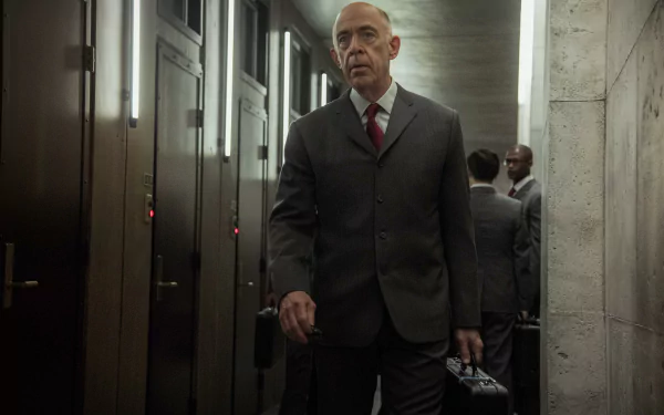 HD wallpaper featuring a man in a suit walking in a dimly lit corridor, a scene from the series Counterpart.