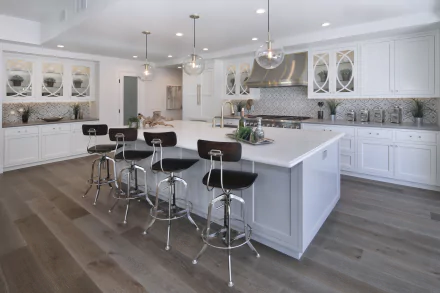 Modern kitchen interior featuring a large island with black stools, white cabinetry, and hardwood flooring, captured in 4K Ultra HD for PC desktop wallpaper.