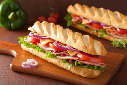 HD wallpaper featuring delicious sandwiches with fresh vegetables, cheese, and meat on crispy bread, set on a wooden board. Tags: bread, food, sandwich.