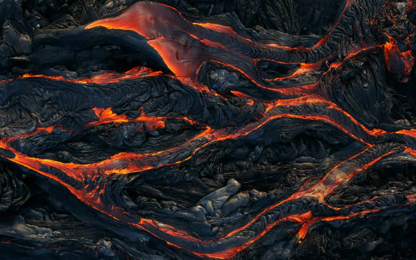 HD PC desktop wallpaper showcasing glowing lava flowing across rugged volcanic terrain, highlighting the raw power of nature.