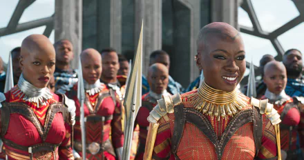 A scene from the movie Black Panther featuring the Dora Milaje, the elite female warriors of Wakanda, dressed in red and gold armor, standing in formation. HD wallpaper and background.