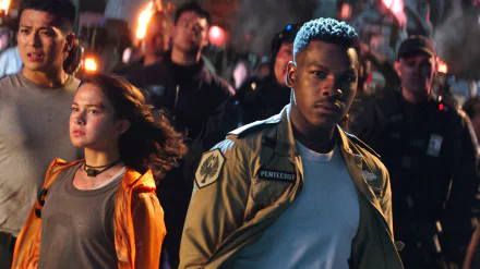 HD wallpaper featuring John Boyega from the movie Pacific Rim: Uprising, with intense expressions, set against a dramatic, action-packed background.