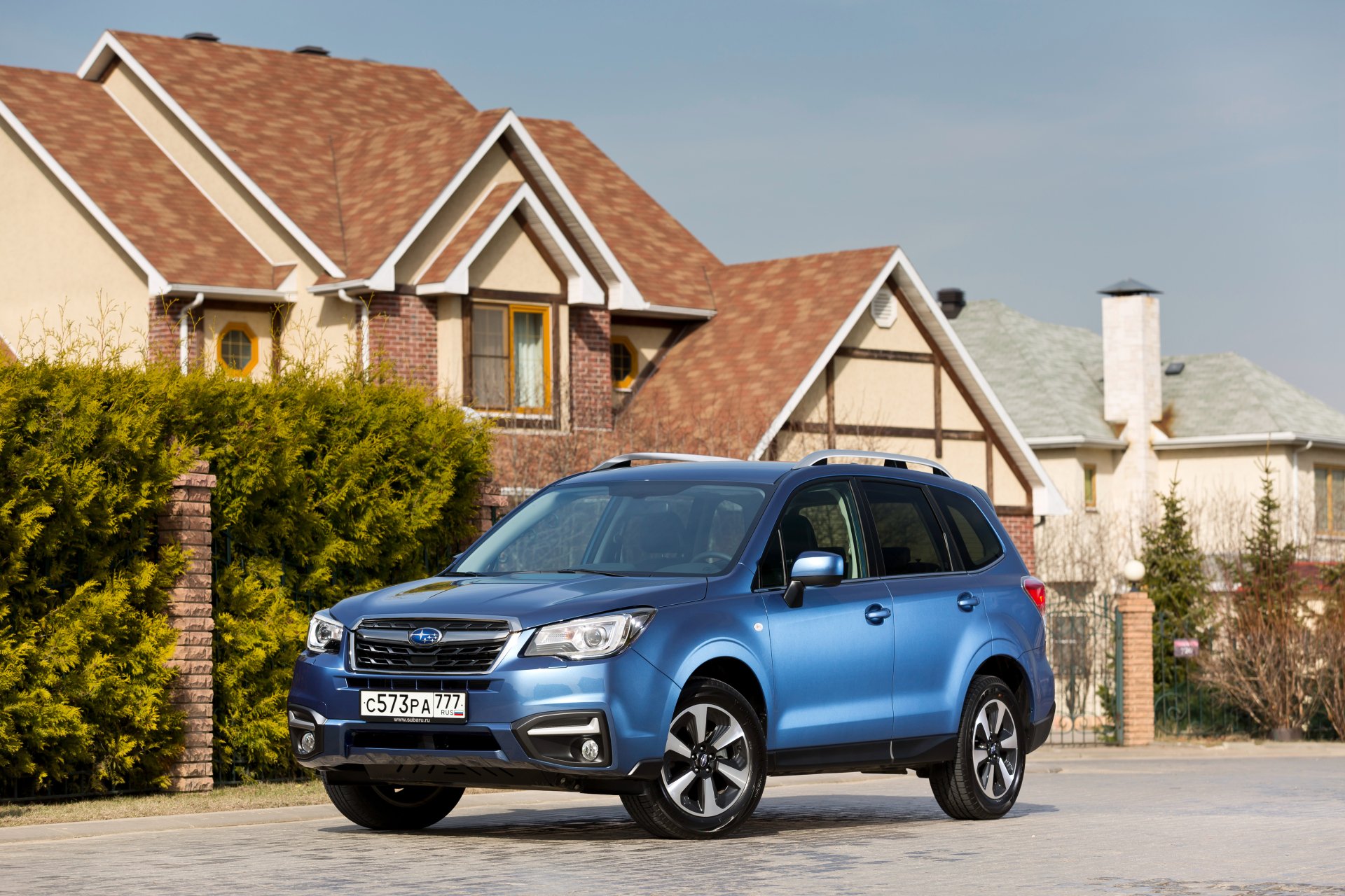 4K Ultra HD PC desktop wallpaper of a blue Subaru Forester SUV parked in front of suburban houses, a Subaru car/vehicle framed against a clear sky.