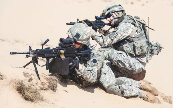 Two soldiers in military gear operate a machine gun while positioned on sand, captured in sharp detail for a 4K Ultra HD PC desktop wallpaper.