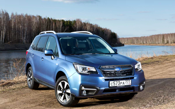 A blue Subaru Forester SUV parked by a lakeside with bare trees in the background, captured in 4K Ultra HD for a PC desktop wallpaper.