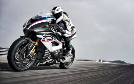 A high-resolution 4K Ultra HD wallpaper of a BMW HP4 motorcycle speeding on a race track, showcasing its sleek design and dynamic motion.
