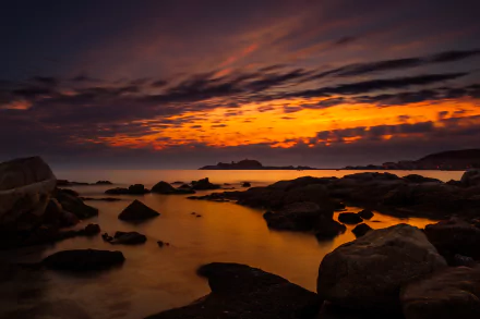 4K Ultra HD photo captures a stunning Corsica ocean sunset with vibrant orange and purple hues reflecting over rocky shorelines.