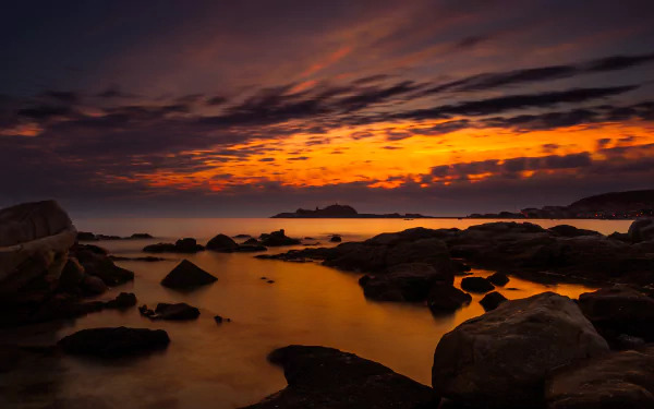 4K Ultra HD photo captures a stunning Corsica ocean sunset with vibrant orange and purple hues reflecting over rocky shorelines.