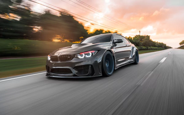 Silver BMW M4 racing down a road with motion blur at sunset — sleek performance vehicle, HD PC desktop wallpaper/background.
