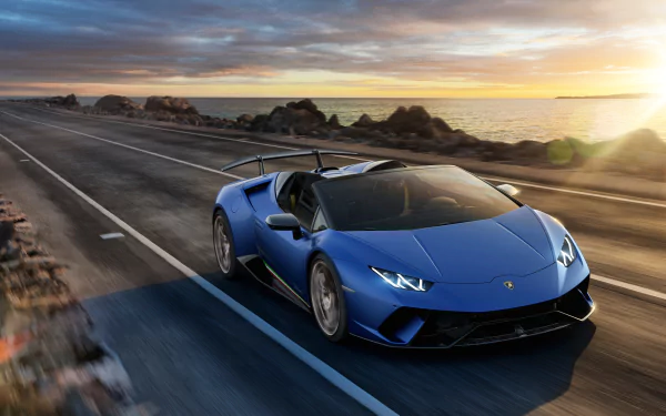 Blue Lamborghini Huracan Performante supercar vehicle on a coastal highway at sunset, 2K Quad HD PC desktop wallpaper background.
