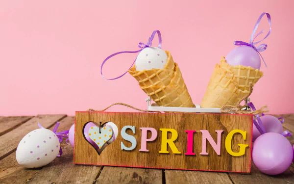 A still life 4K Ultra HD wallpaper featuring pastel eggs in waffle cones with purple ribbons, set against a pink background and a wooden SPRING sign.