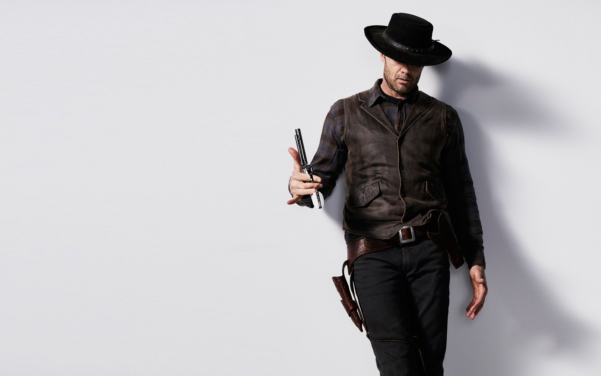 HD desktop wallpaper featuring a character from the TV show Fear the Walking Dead, dressed in dark western attire and holding a weapon against a white background.