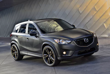 Silver Mazda CX-5 SUV parked against a modern textured wall, showcased in a high-resolution 4K Ultra HD desktop wallpaper and background.