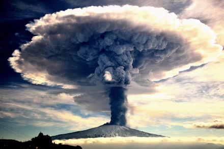 A stunning HD desktop wallpaper featuring a powerful volcanic eruption, with a massive mushroom cloud of smoke billowing into the sky, showcasing the raw beauty of nature's force.