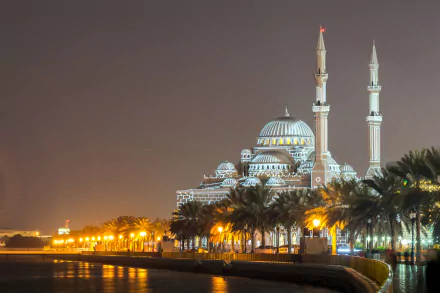 Al Noor Mosque in Sharjah, United Arab Emirates, illuminated at night with its grand architecture reflected in the surrounding water, captured in 4K Ultra HD.