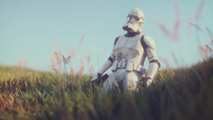 A HD desktop wallpaper featuring a clone trooper figurine from Star Wars, standing in a grassy field with clear blue sky in the background.