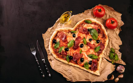 HD desktop wallpaper of a heart-shaped pizza topped with olives, basil, and sliced meat, displayed on rustic parchment with tomatoes, garlic, olive oil, and cutlery in a still life style.
