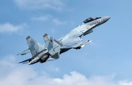 HD desktop wallpaper of a Sukhoi Su-35 military jet fighter soaring through a clear blue sky, showcasing powerful warplane design and advanced aircraft technology.