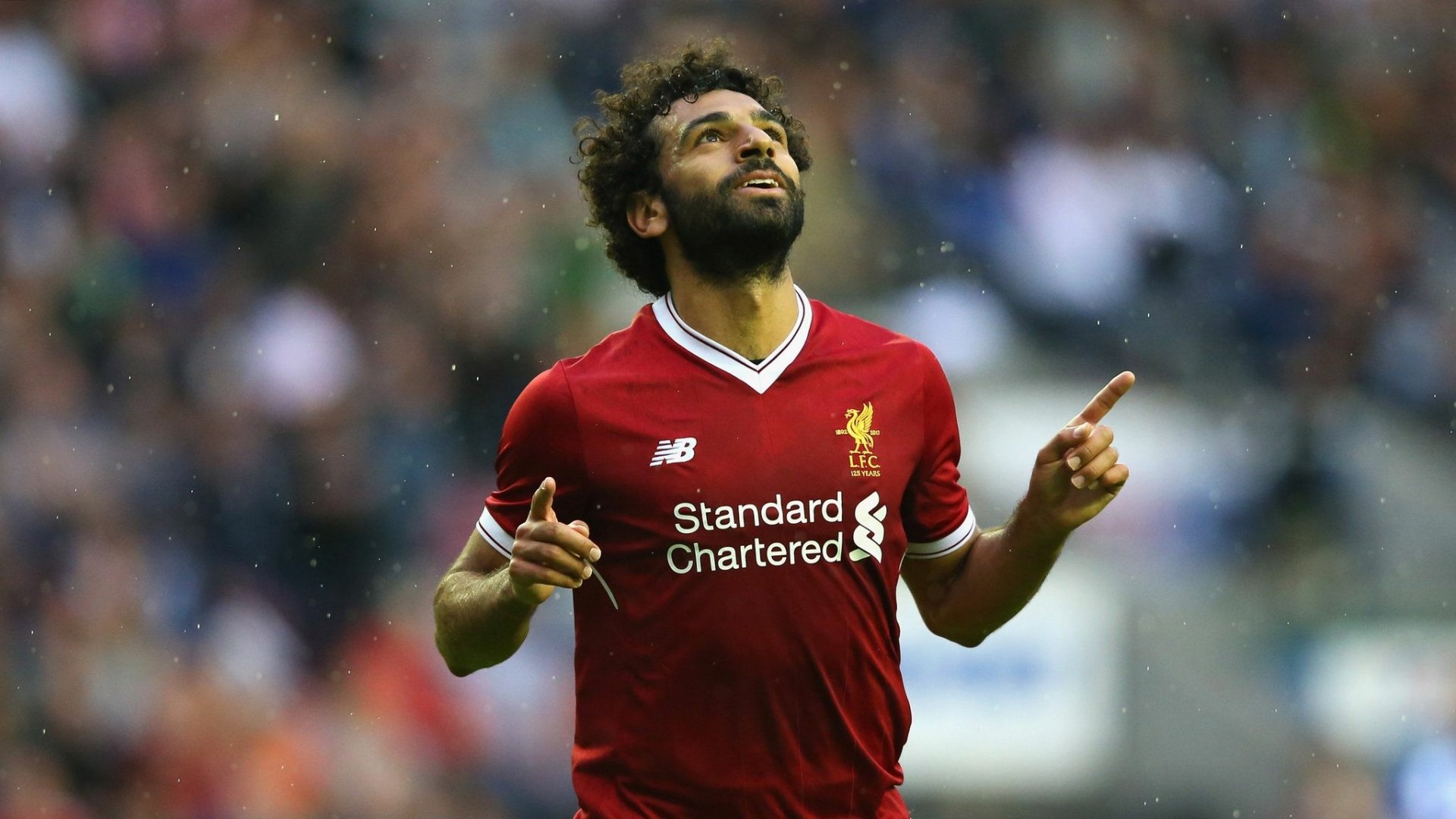 HD PC desktop wallpaper featuring Mohamed Salah in a red Liverpool jersey celebrating on the football field during a sports event.