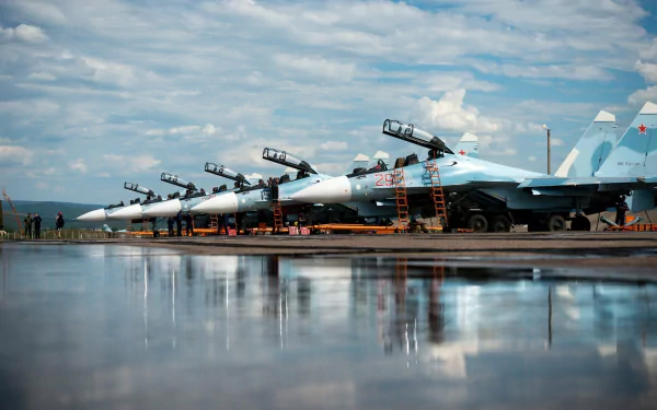 A reflection of multiple Sukhoi Su-30 jet fighters lined up on a tarmac under a partly cloudy sky, captured as an HD desktop wallpaper and background.