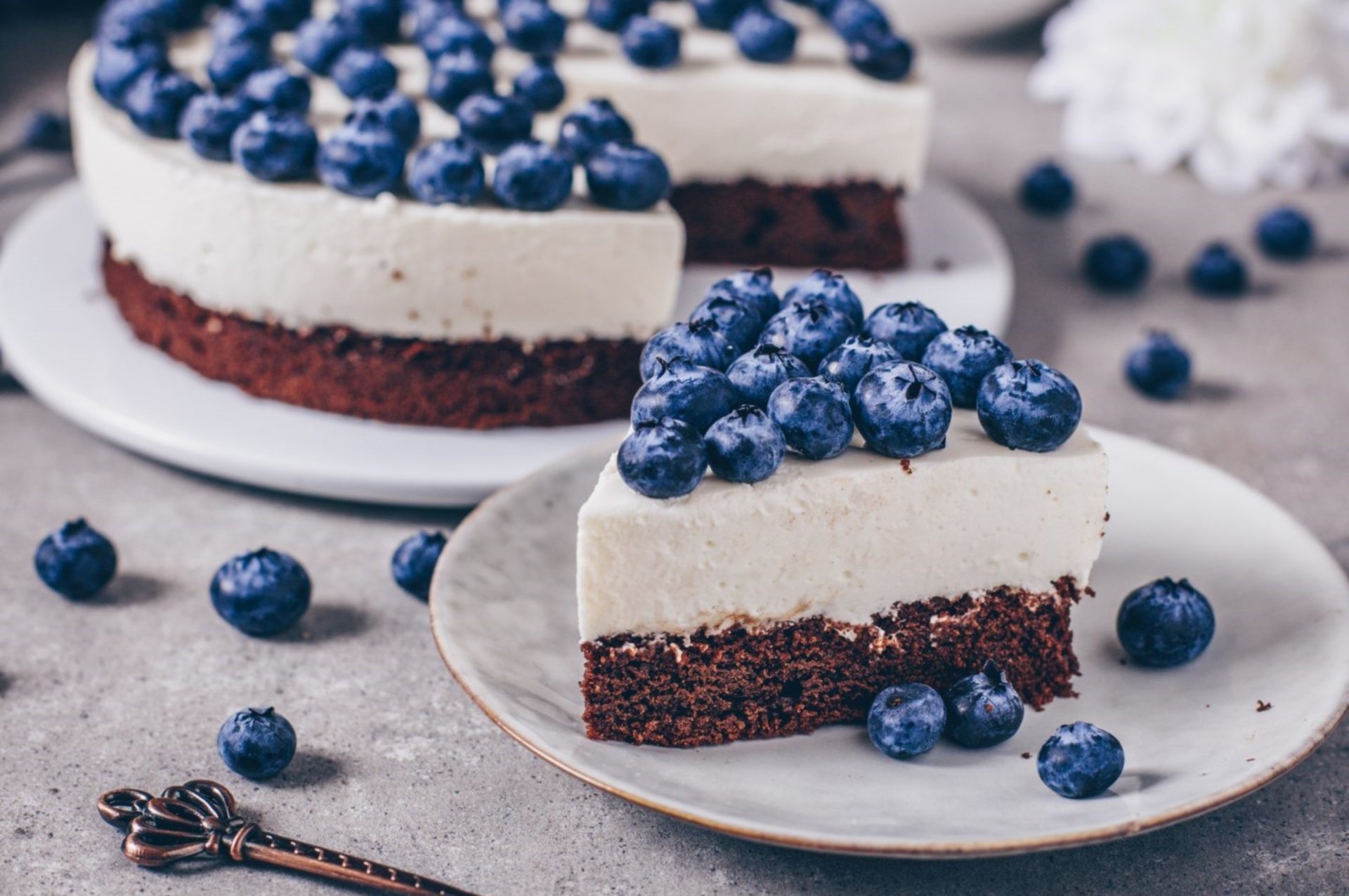 A slice of blueberry cheesecake with fresh berries on top, set against a gray background, showcased as an HD PC desktop wallpaper and background.