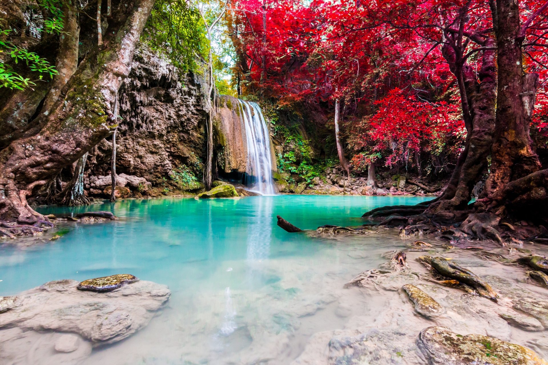 5K Ultra HD PC desktop wallpaper/background: turquoise lake with a cascading waterfall, mossy rocks and vivid red trees framing a serene nature scene.