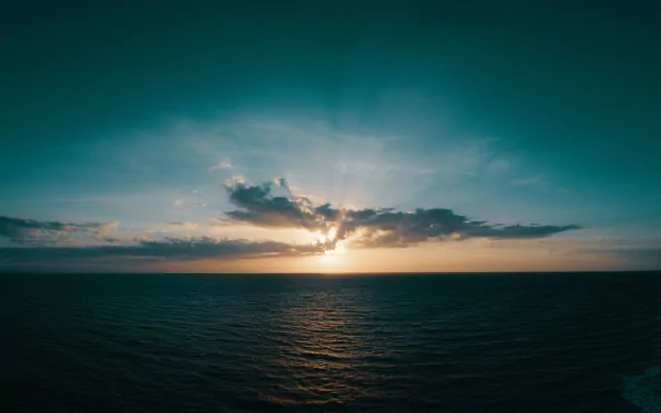 HD desktop wallpaper of a serene sunrise over the ocean, with vibrant hues in the sky and the horizon meeting the calm waters. Perfect nature backdrop showcasing the beauty of dawn over the sea.