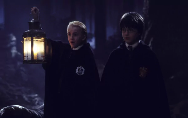 2K Quad HD wallpaper: two Hogwarts students in dark cloaks—one holding a lantern—scene from Harry Potter and the Philosopher's Stone with Harry Potter and Draco Malfoy.