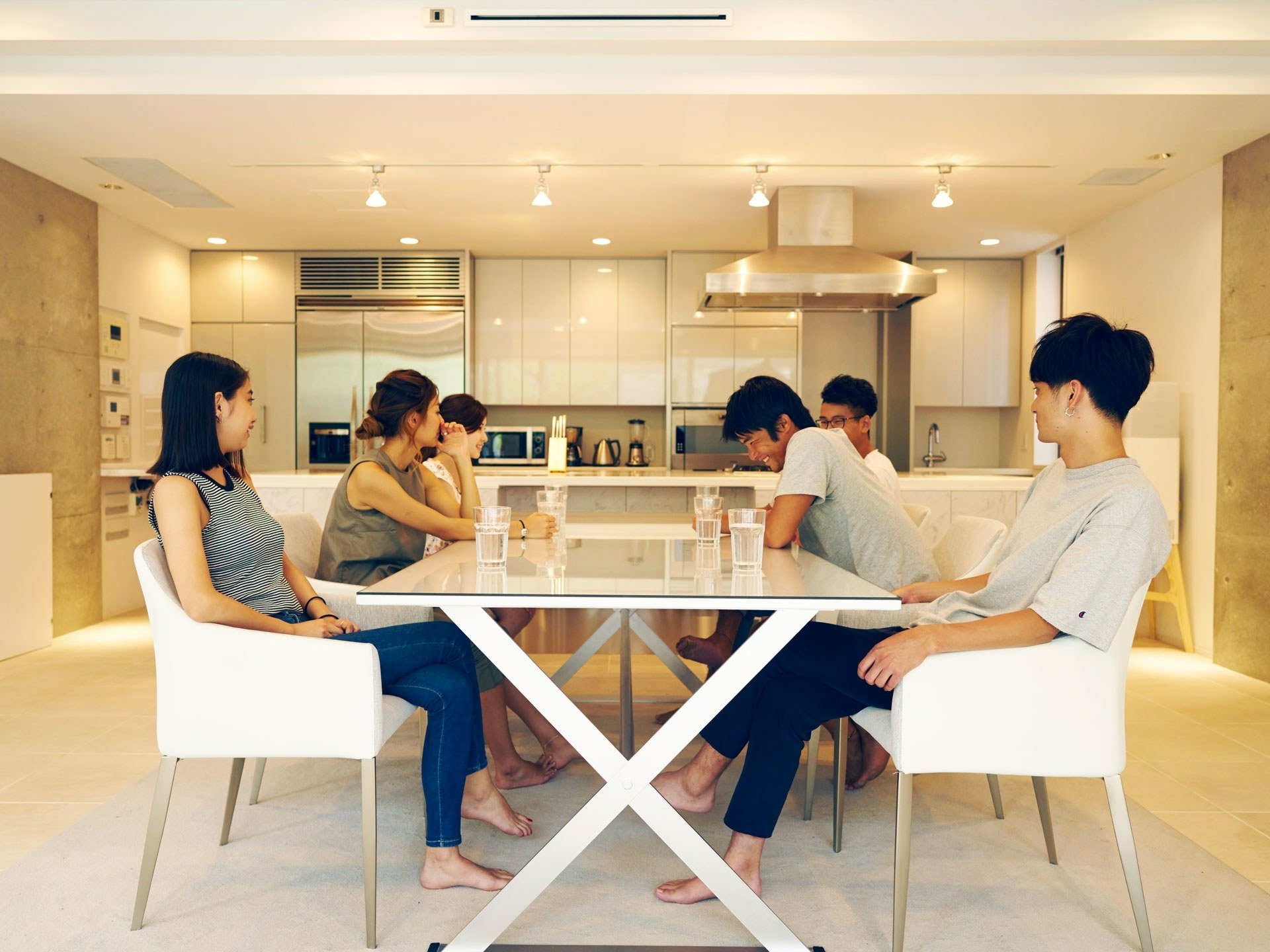 HD wallpaper of people sitting around a table in a modern terrace house with a light interior design.