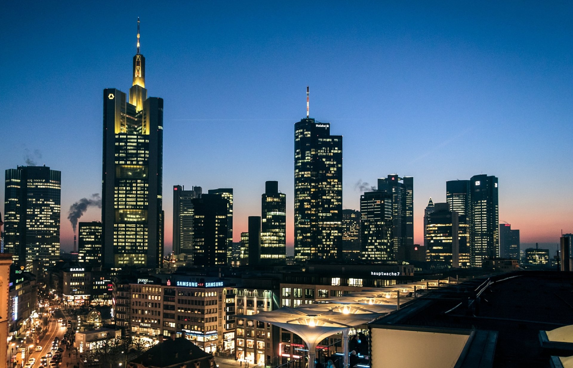 Frankfurt, Germany night skyline of illuminated man-made skyscrapers and city buildings against twilight — 2K Quad HD PC desktop wallpaper.