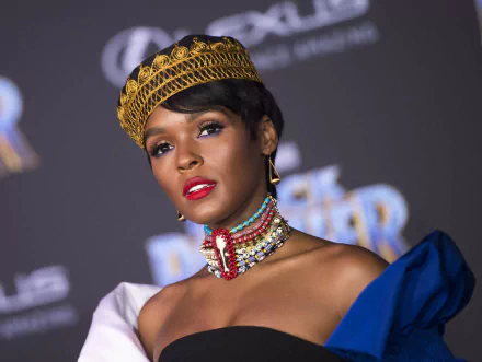 HD desktop wallpaper featuring a person with a golden headpiece, vibrant necklace, and blue attire, posing confidently.