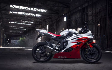 HD desktop wallpaper featuring a Yamaha R6 motorcycle in a dimly lit industrial warehouse, showcasing the sporty design of the Yamaha vehicle.