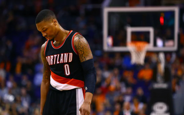 HD wallpaper of Damian Lillard in a Portland Trail Blazers jersey on the basketball court, looking down thoughtfully.