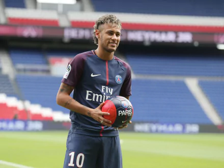 High-resolution 4K Ultra HD image of Brazilian soccer star Neymar in a Paris Saint-Germain jersey, holding a soccer ball on the field.