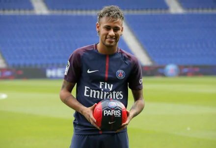 4K Ultra HD wallpaper of Brazilian soccer star Neymar in a Paris Saint-Germain jersey, holding a football on a stadium field.