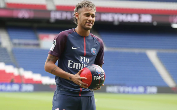 High-resolution 4K Ultra HD image of Brazilian soccer star Neymar in a Paris Saint-Germain jersey, holding a soccer ball on the field.