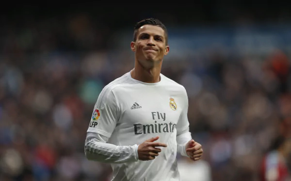HD wallpaper featuring Portuguese soccer player Cristiano Ronaldo in a white jersey, on the field during a match.