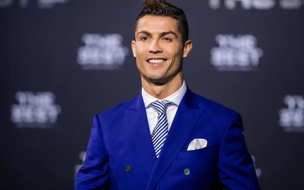 HD desktop wallpaper featuring Portuguese soccer star Cristiano Ronaldo, dressed in a stylish blue suit, smiling against a dark background. Tags: Portuguese, soccer, Cristiano Ronaldo, sports.