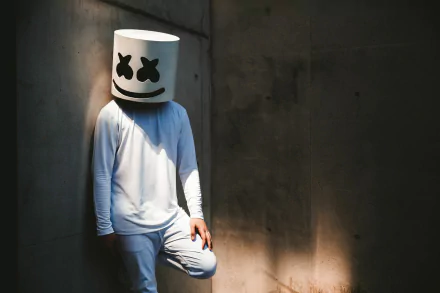 HD desktop wallpaper featuring Marshmello, the DJ, standing in a corner, dressed in his iconic white outfit and helmet.
