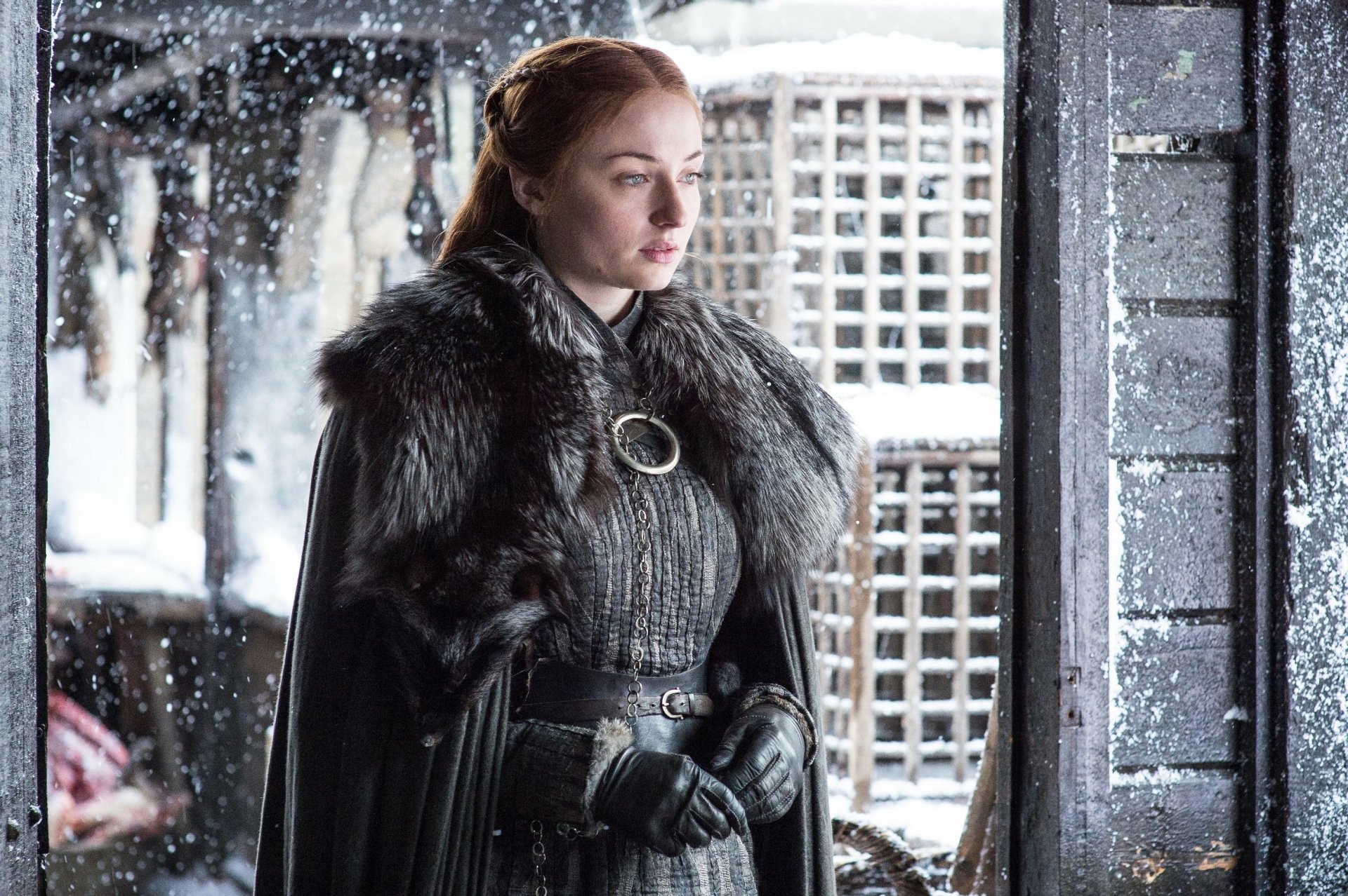HD PC desktop wallpaper featuring Sophie Turner as Sansa Stark from the TV show Game of Thrones, standing in a snowy medieval setting.