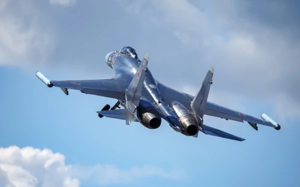 Sukhoi Su-35 military jet fighter warplane soars against a cloudy sky, captured in this HD desktop wallpaper and background image.