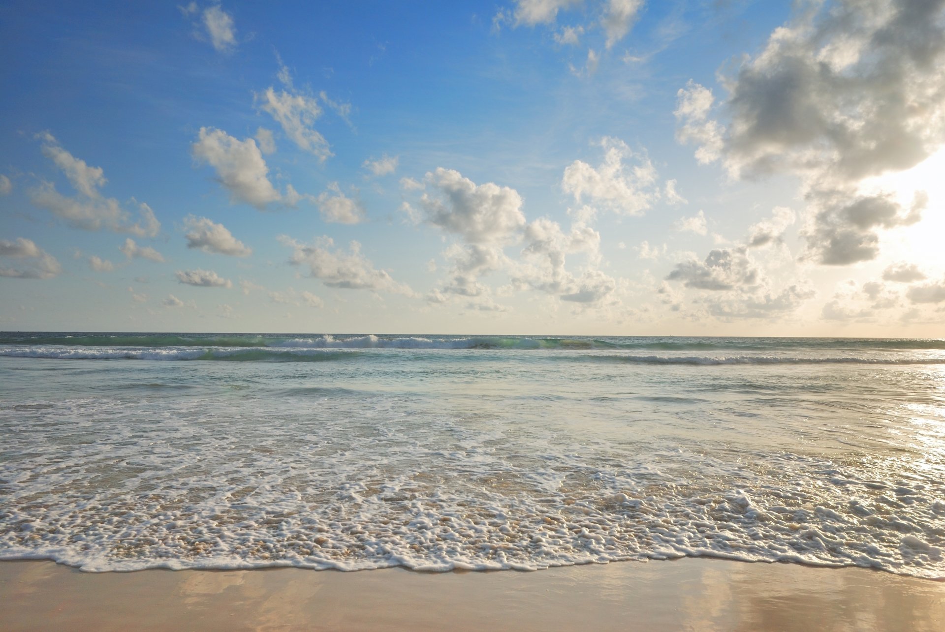 4K Ultra HD desktop wallpaper showcasing a serene ocean horizon under a bright sky dotted with fluffy clouds, capturing the beauty of nature.