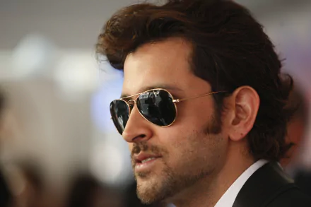 HD desktop wallpaper of a man with stubble and sunglasses, exuding charisma and style.