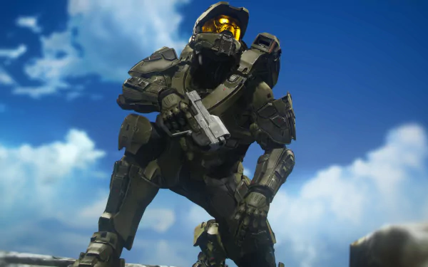 Master Chief from Halo in full armor crouches with rifle on a rocky outcrop under a blue sky — 4K Ultra HD PC desktop wallpaper/background, video game artwork.