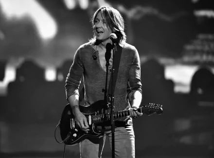HD desktop wallpaper featuring a grayscale photo of a musician onstage with a guitar, tagged with Keith Urban.