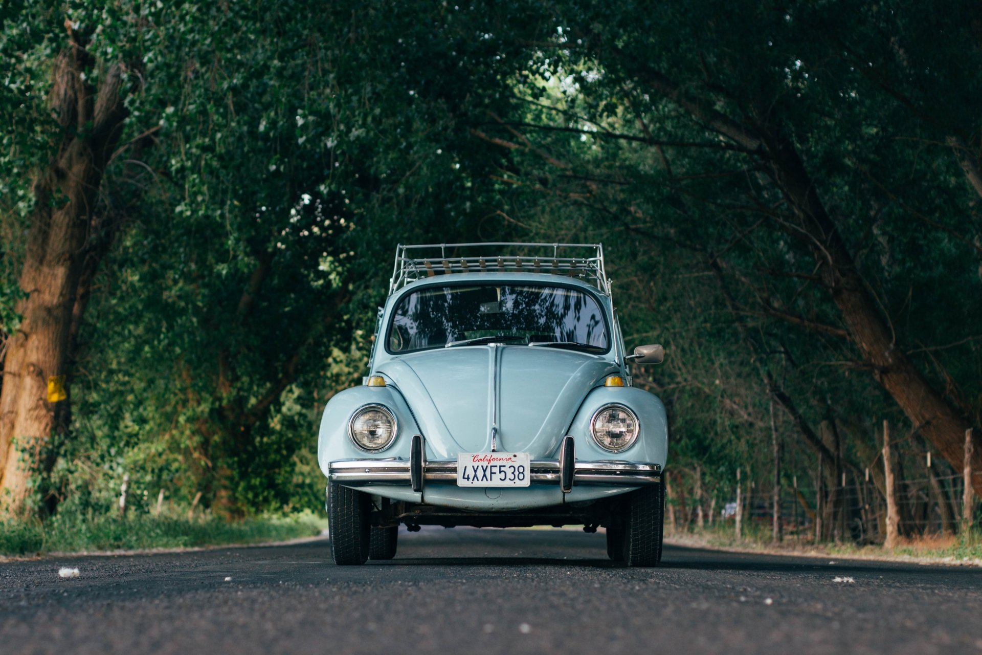Front view of a light blue Volkswagen Beetle parked on a shaded road, captured in crisp detail as a 4K Ultra HD PC desktop wallpaper background.