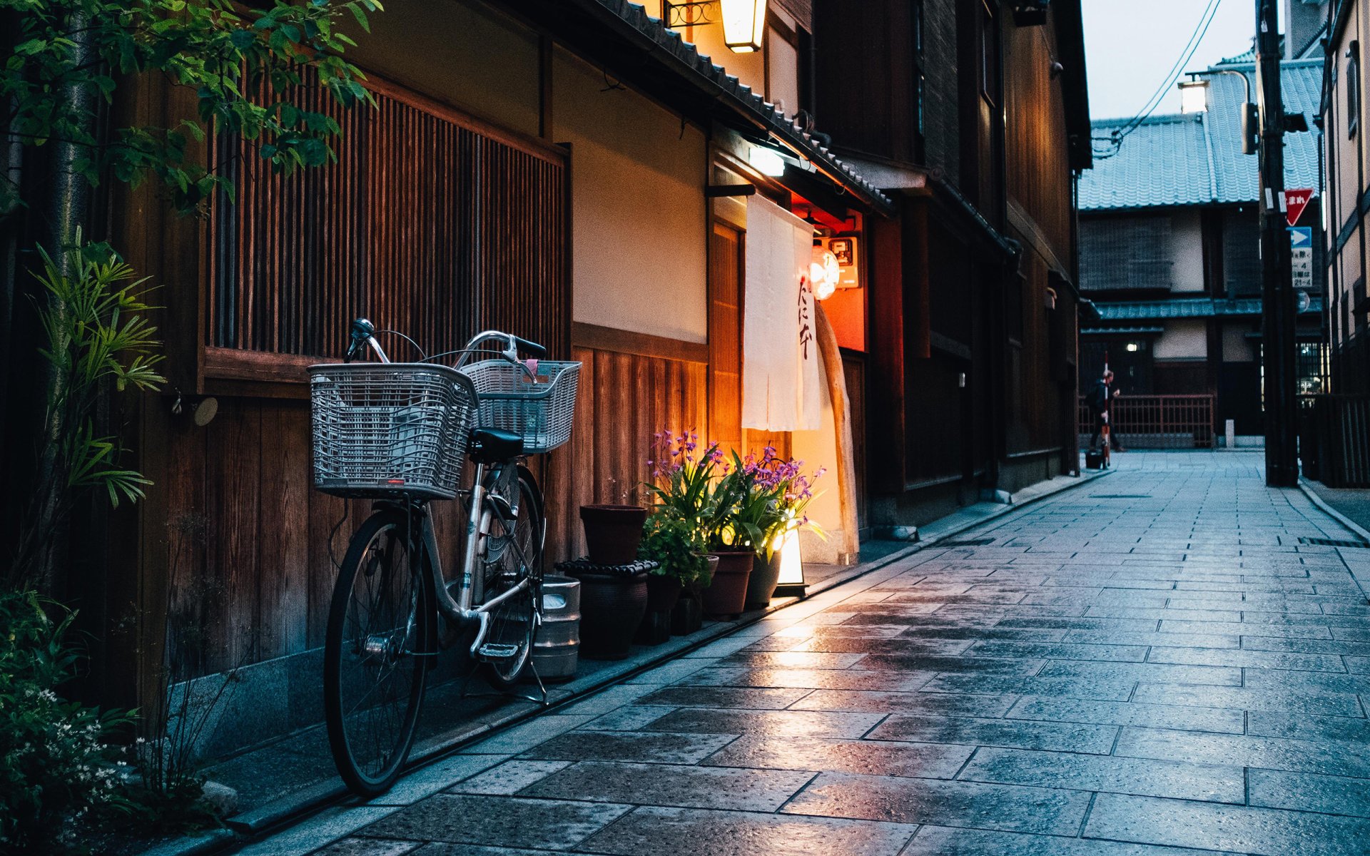 A bicycle parked along a quiet, narrow street with traditional wooden buildings at dusk, captured in a high-definition PC desktop wallpaper background.