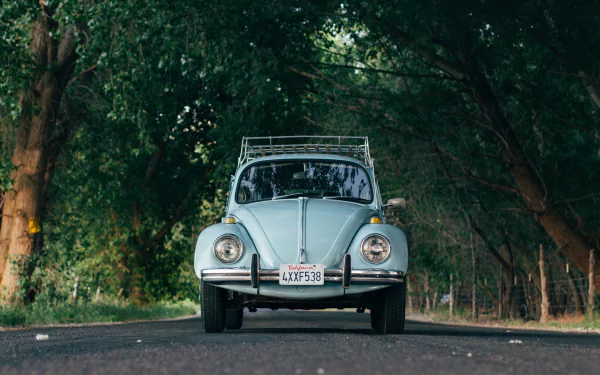 Front view of a light blue Volkswagen Beetle parked on a shaded road, captured in crisp detail as a 4K Ultra HD PC desktop wallpaper background.