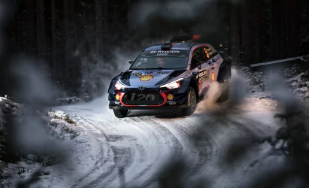 A rallying race car speeds through a snowy forest track, captured in stunning 4K Ultra HD as a dynamic sports vehicle in action.
